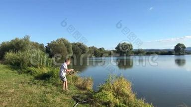 在湖边钓鱼的男孩。 美丽的鱼塘巴丁附近，班斯卡比斯特里察，斯洛伐克。 捕鱼的地方。